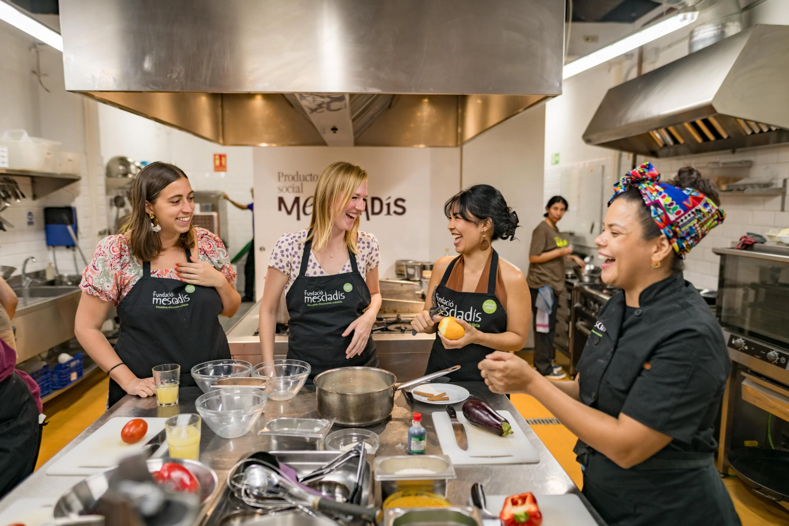 Chef and guests laughing during cooking class in Barcelona