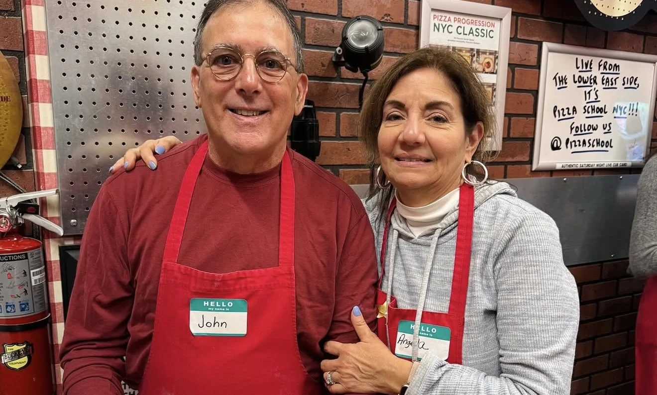 Couple posing with their made pizza