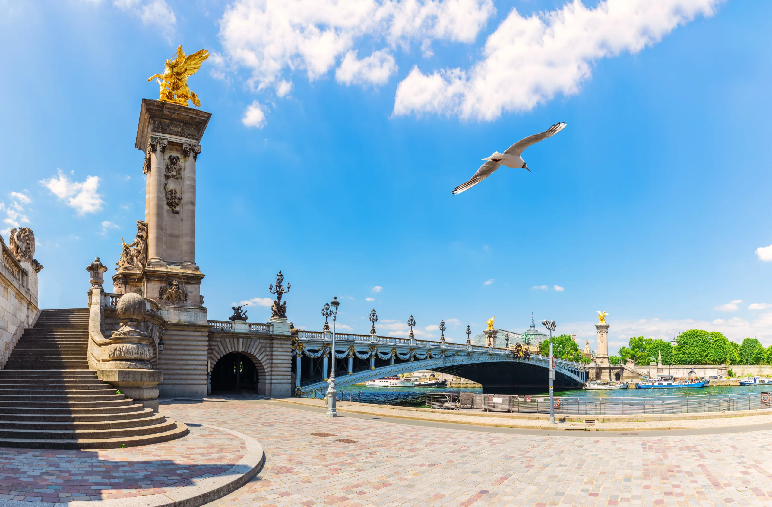 Elegant view of Alexandre III Bridge over Seine river, with sculptures and waterfront steps