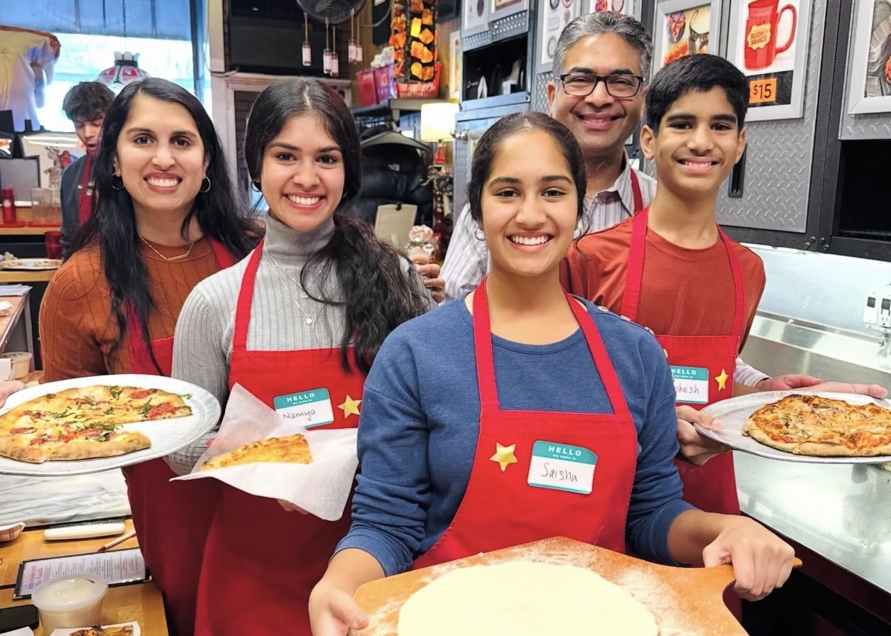 Family making pizzas during Pizza-Making Workshop and Dinner in NYC