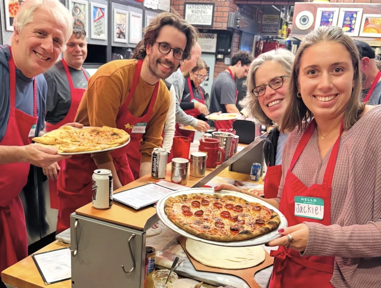 Group of four posing with their pizzas during NYC Pizza-Making Workshop