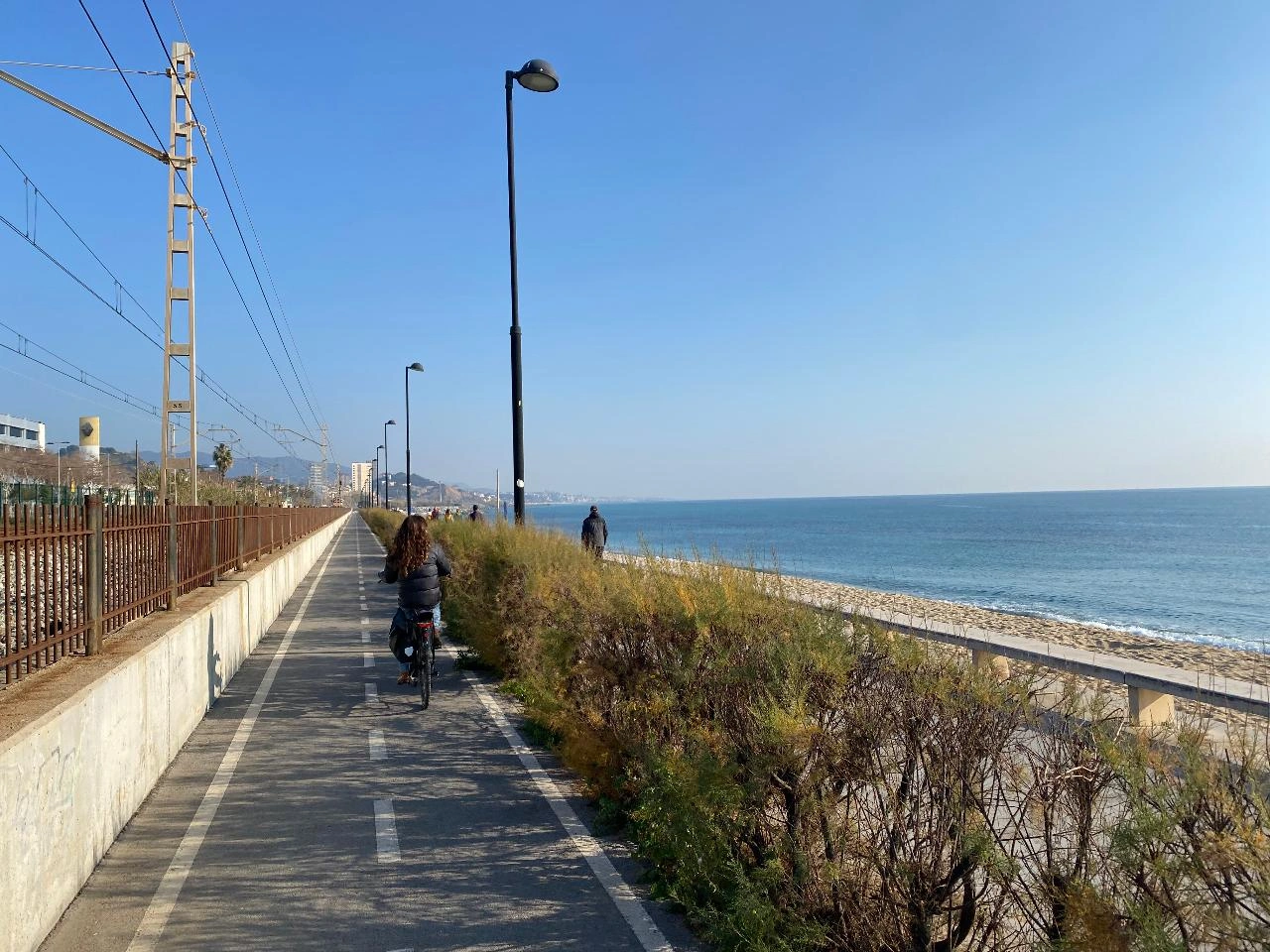 Guests cycling by the seaside in Alella wine region