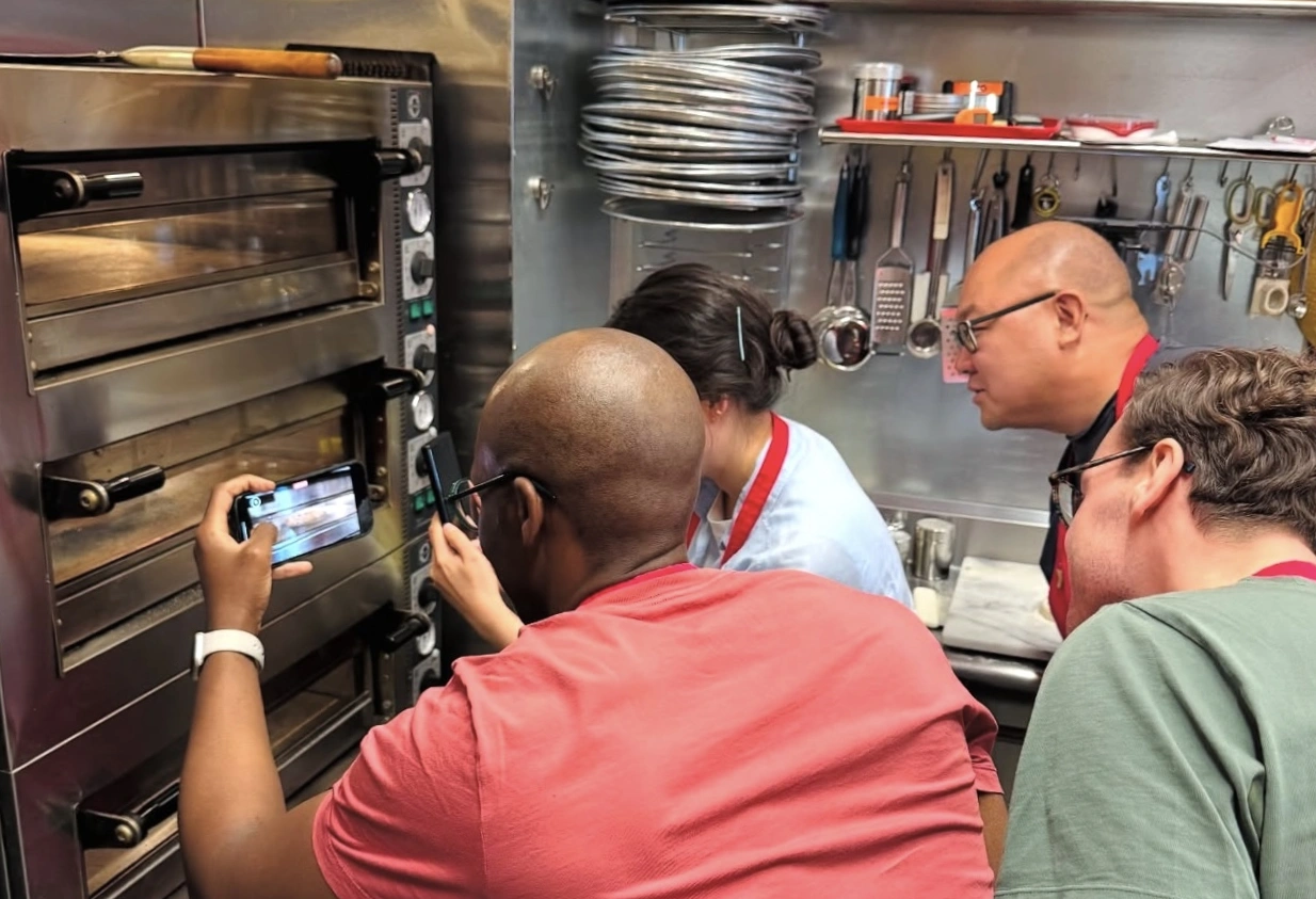 Guests taking photos of pizza in the oven