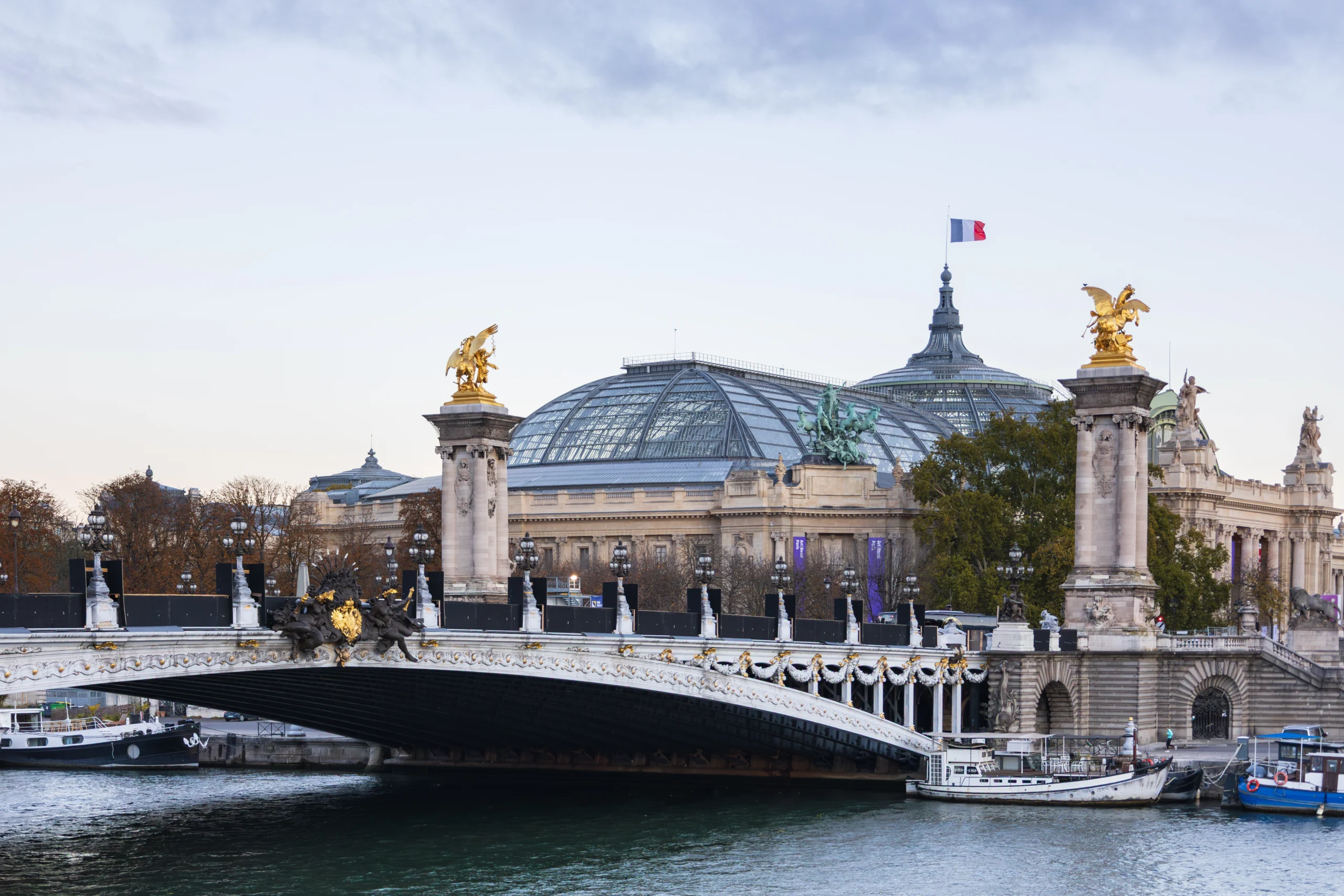 The 1900 Beaux-Arts style Alexandre III deck arch bridge over the Seine river seen at dawn