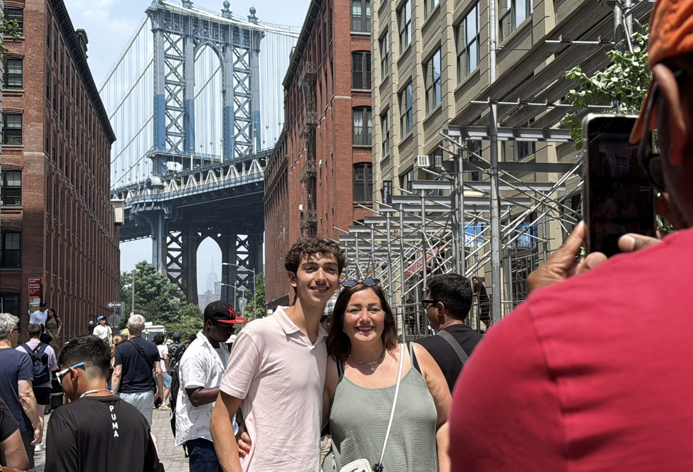 Two people taking a photo with Brooklyn Bridge during Beyond Manhattan private guided tour