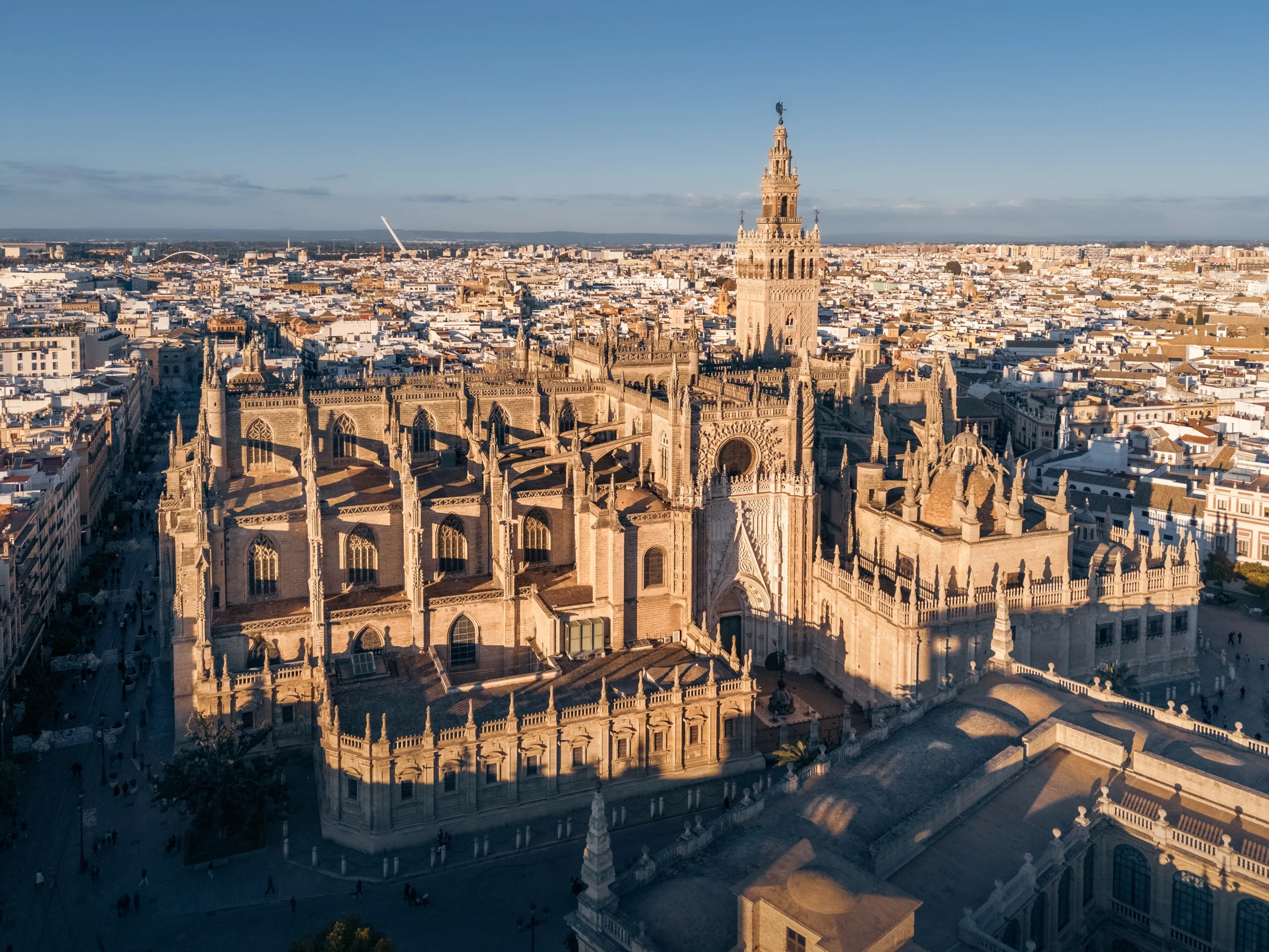 Aerial cityscape with Seville Cathedral and white buildings of old city at sunset