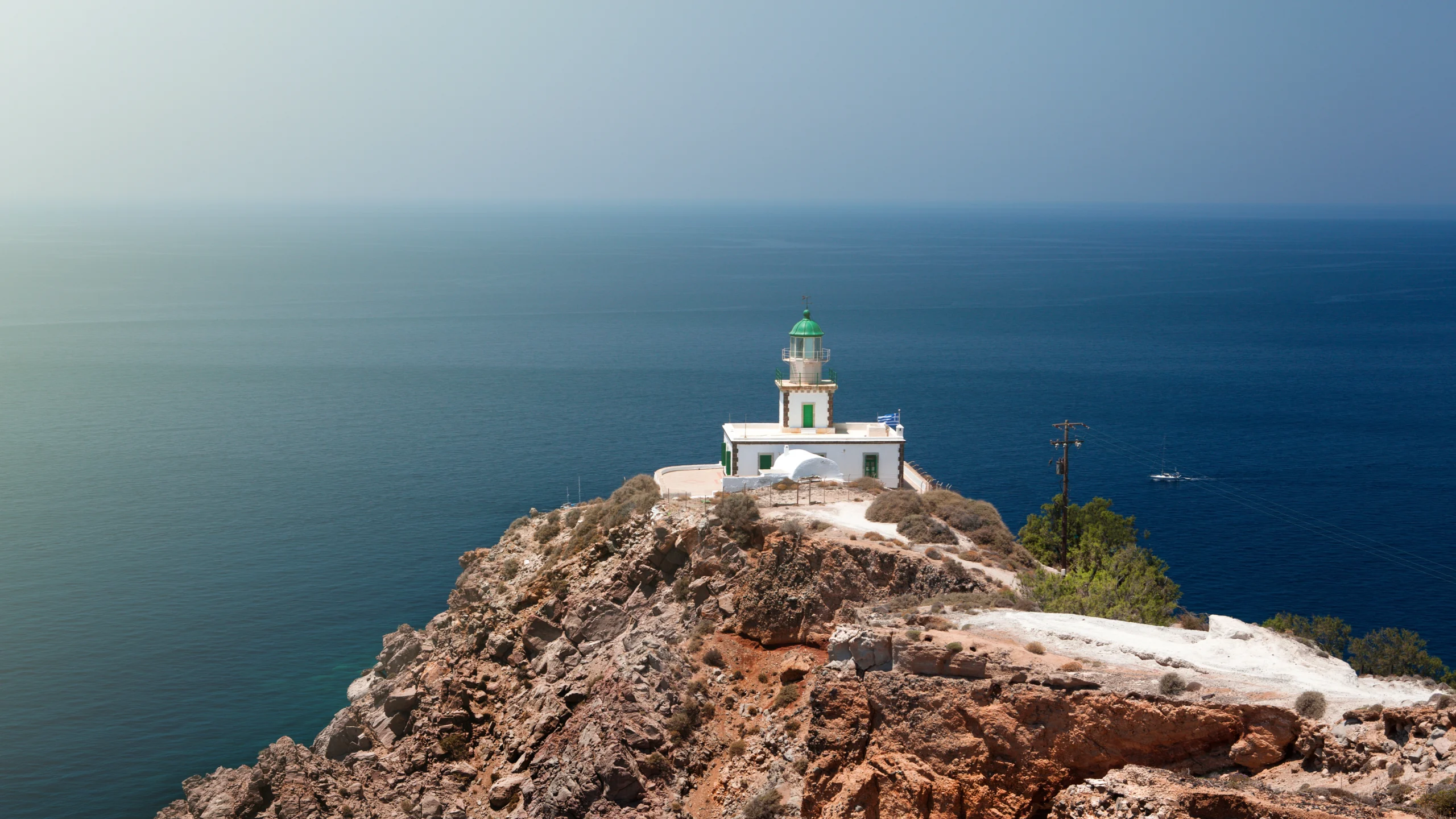 Aerial view of Akrotiri Lighthouse during premium Caldera Sunset Sail experience in Santorini