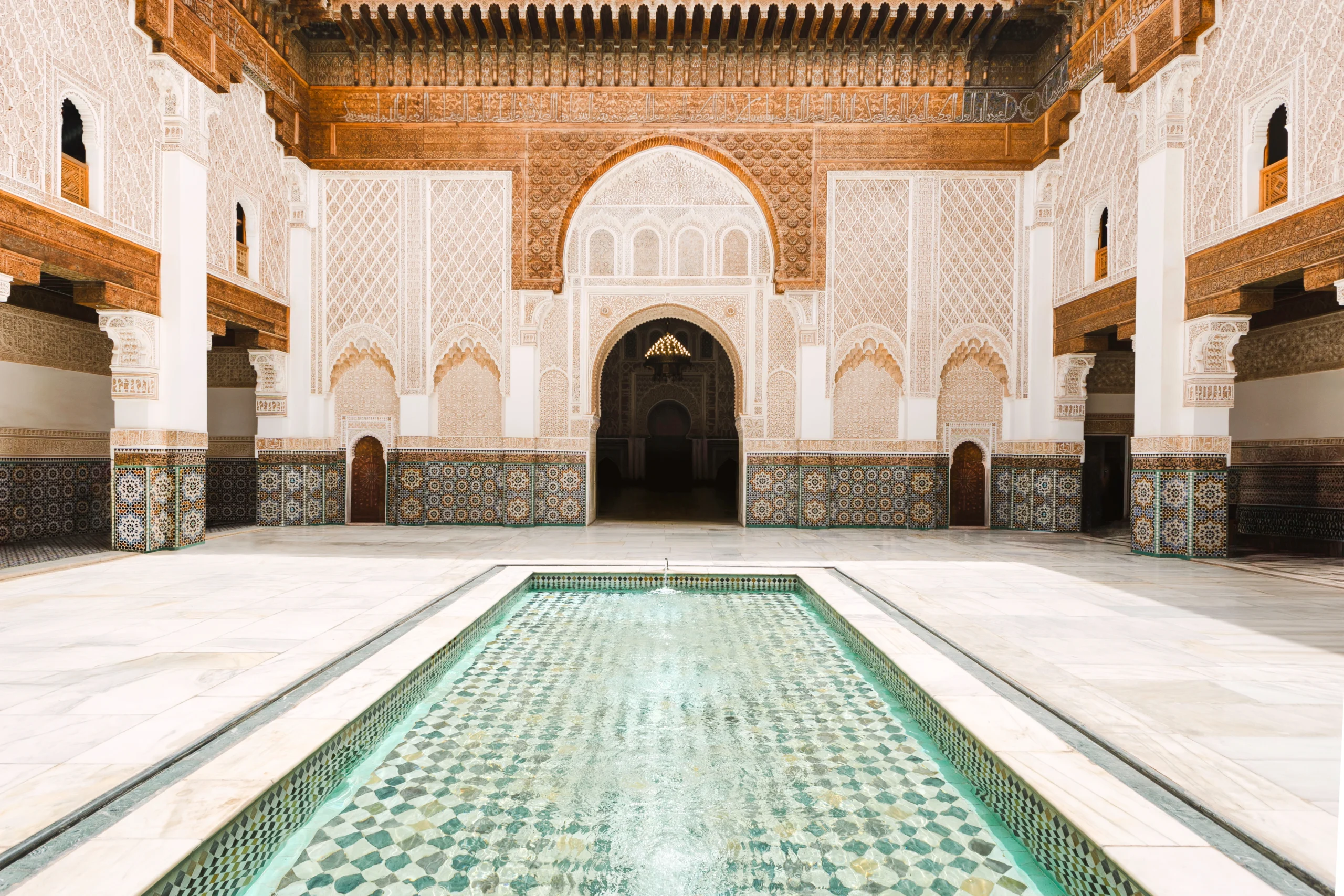 Ben youssef madrasa courtyard with intricate tile mosaics and water pool in Marrakech during Marrakech Through Time With a Moroccan Historian experience
