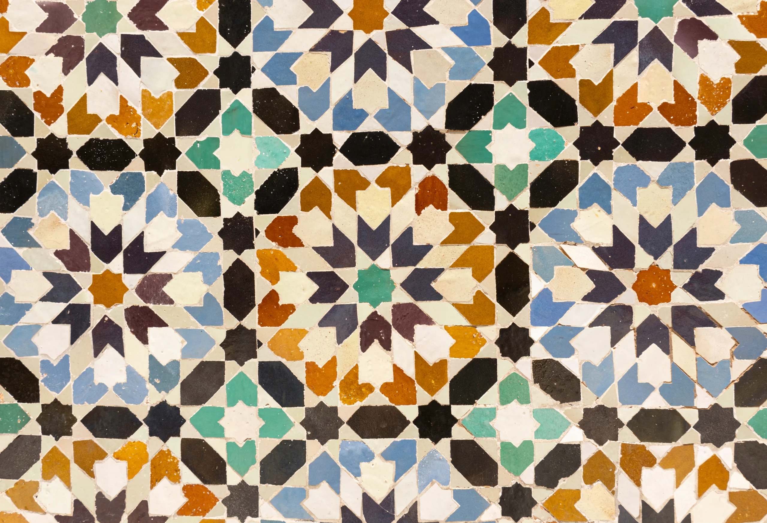 Closeup of colorful mosaic geometric pattern zellige tiles at Ben Youssef Madrasa in Marrakech, Morocco
