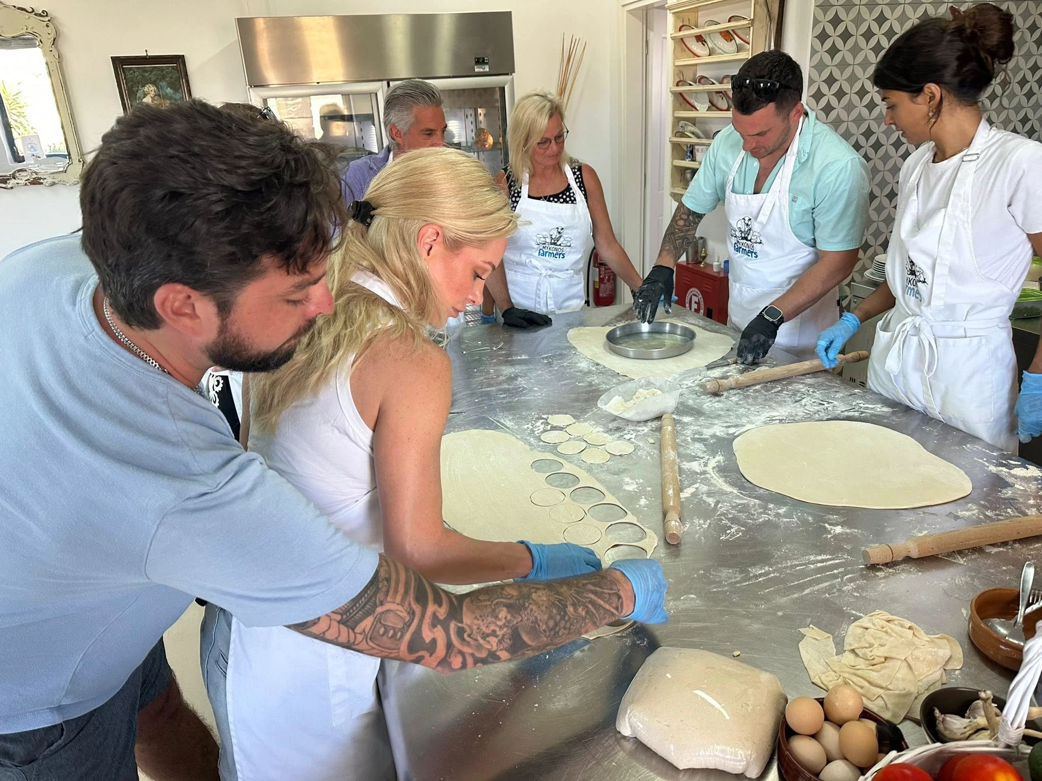 Couple cooking togethrer in cheese cooking workshop in Mykonos Greece