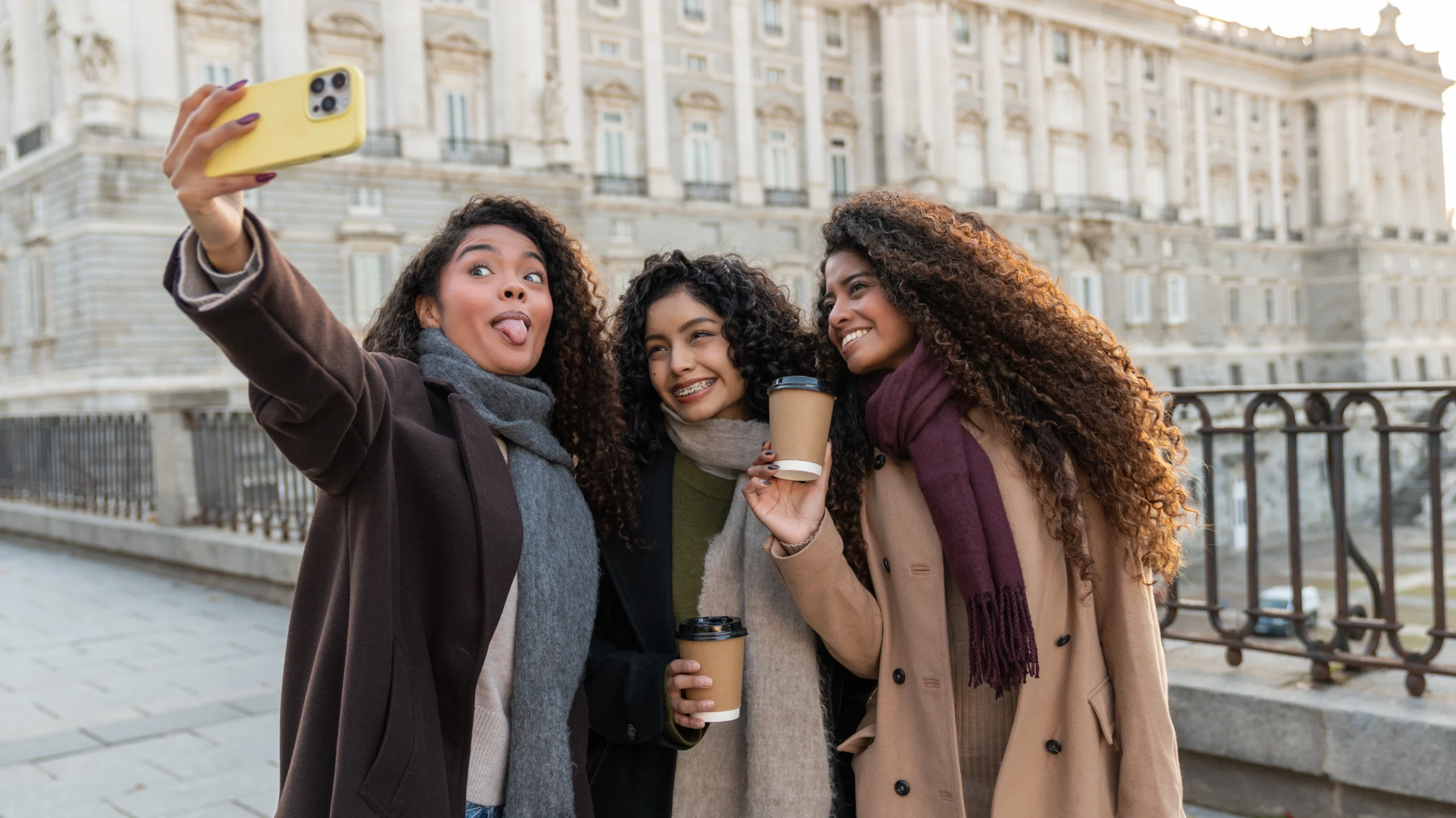 Friends taking selfie in front of the Royal Palace of Madrid during Prado Museum & Royal Palace With a Historian experience