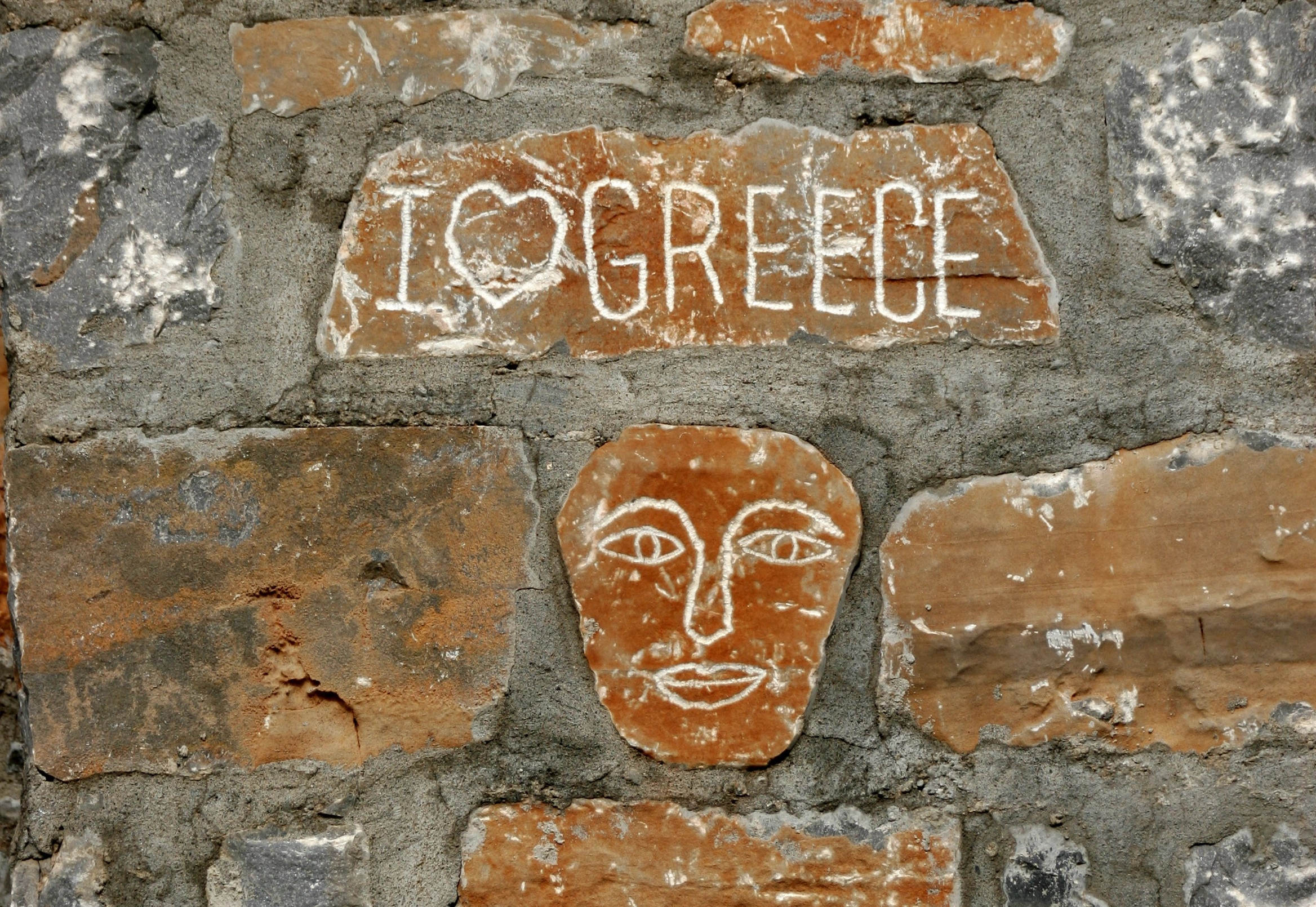 I Love Greece carved into a brick wall