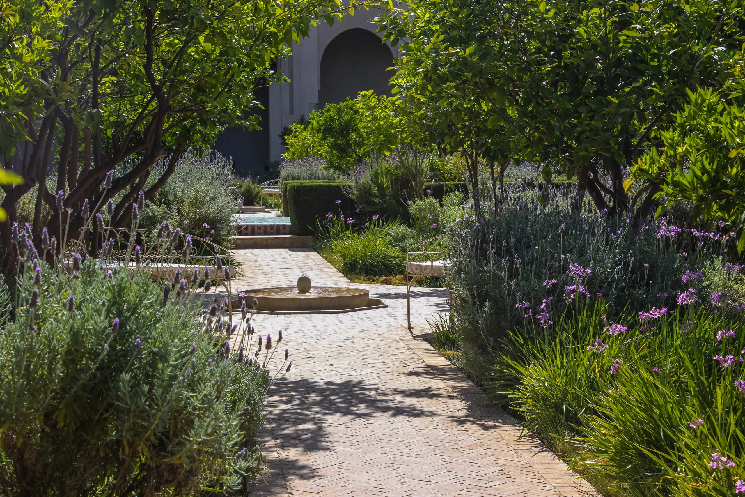 Le Jardin secret stone pathway with small fountain in the middle