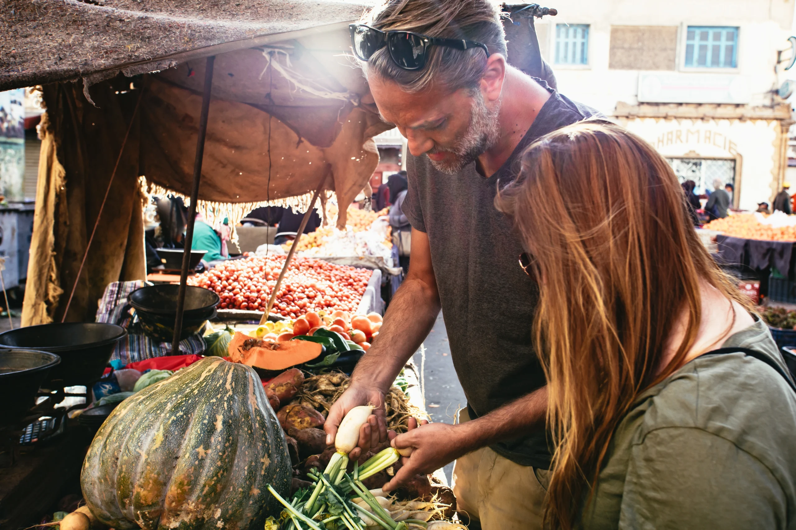 Man and woman shopping for fresh vegetables during Moroccan Family Kitchen experience in Marrakech