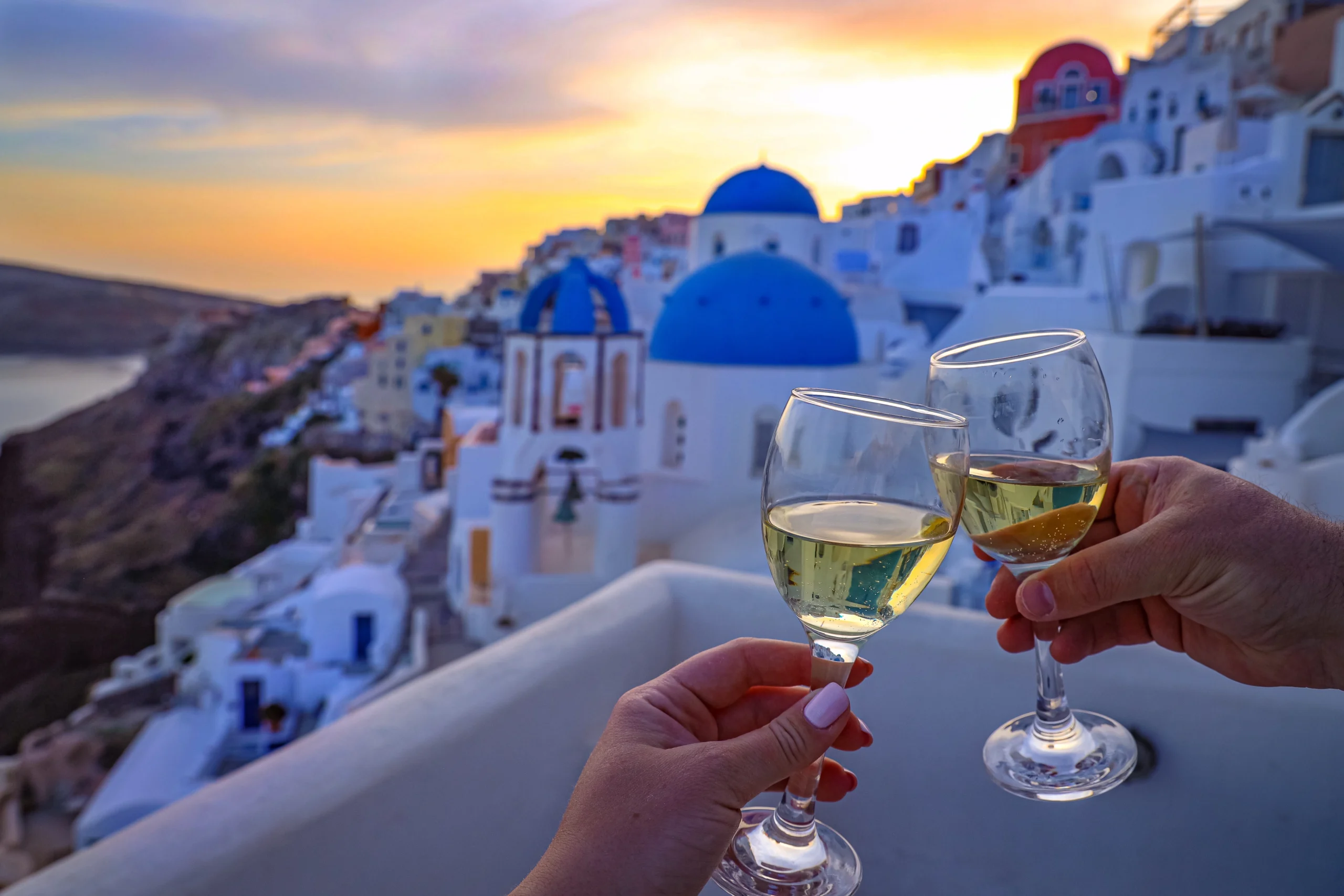Toasting wine glasses during sunset in Santorini during private Santorini experience