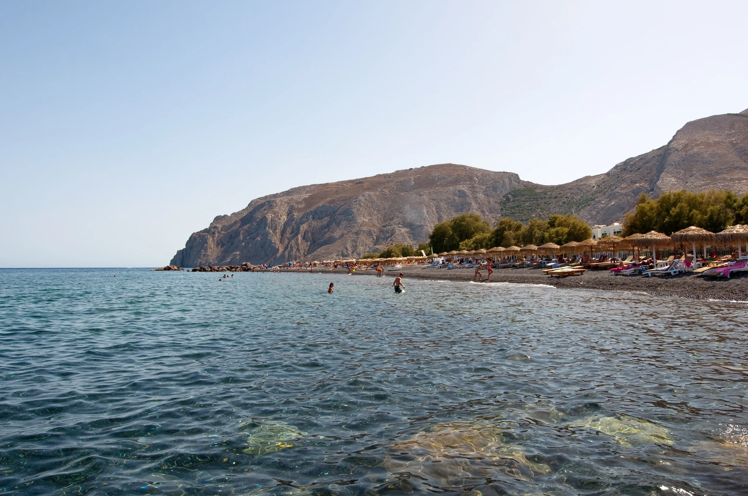 Tourists sunbathe on the Kamari Beach