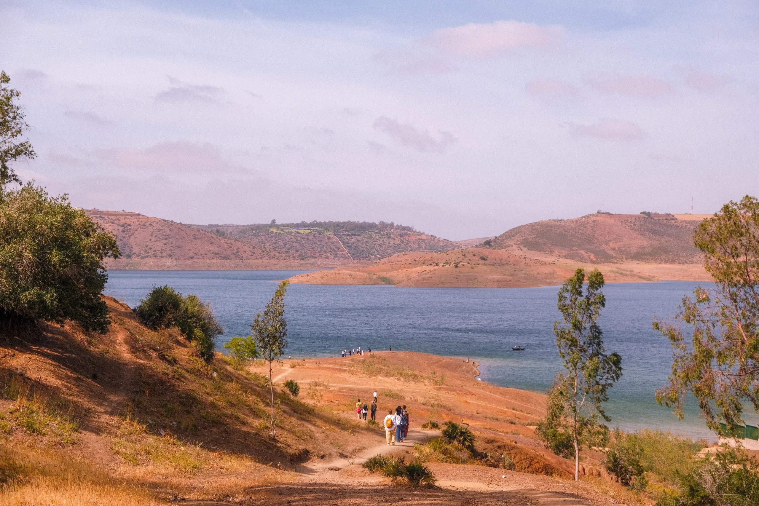 view of a large lake near Marrakech with small figures of people gathered along its sandy edge