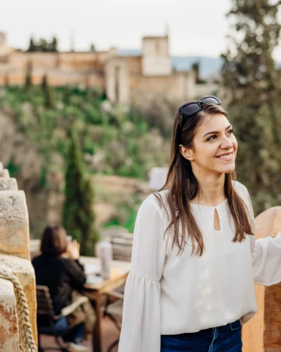 Smiling woman sightseeing old historic landmarks with Alhambra in the background