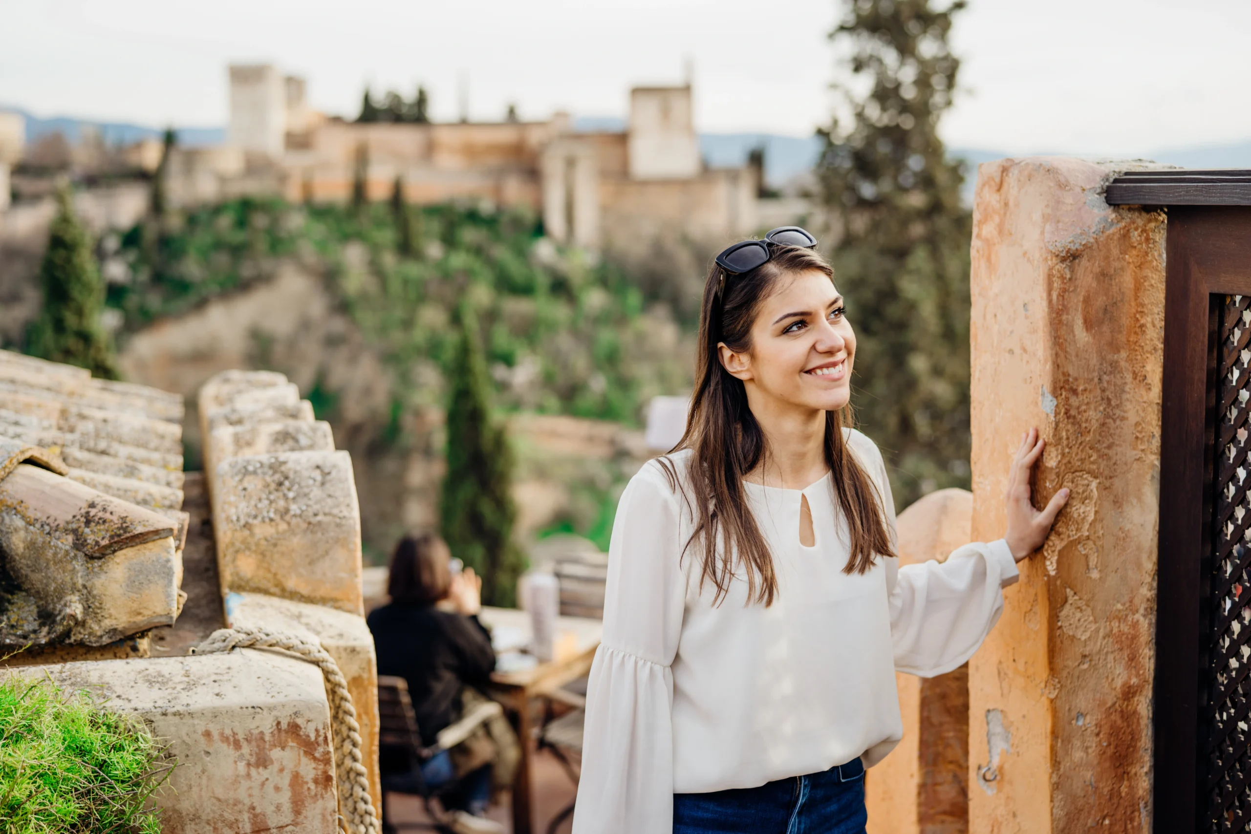 Smiling woman sightseeing old historic landmarks with Alhambra in the background