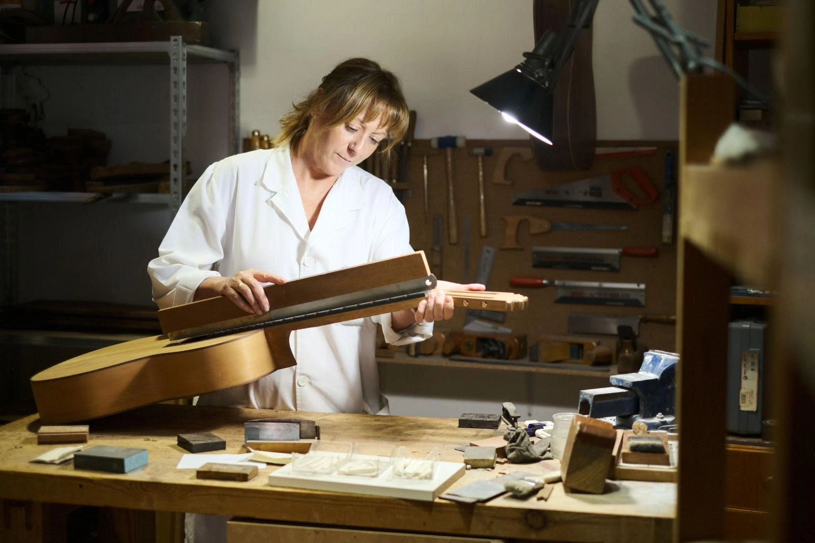 Woman sanding guitar during Guitar Workshop in Granada
